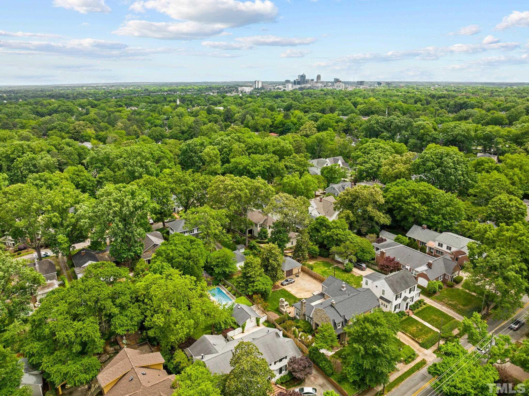 Drone is hovering directly above 2217 St. Mary's Street looking over the tree line at Downtown Raleigh. Close and convenient to so many things while maintaining a private oasis feel.