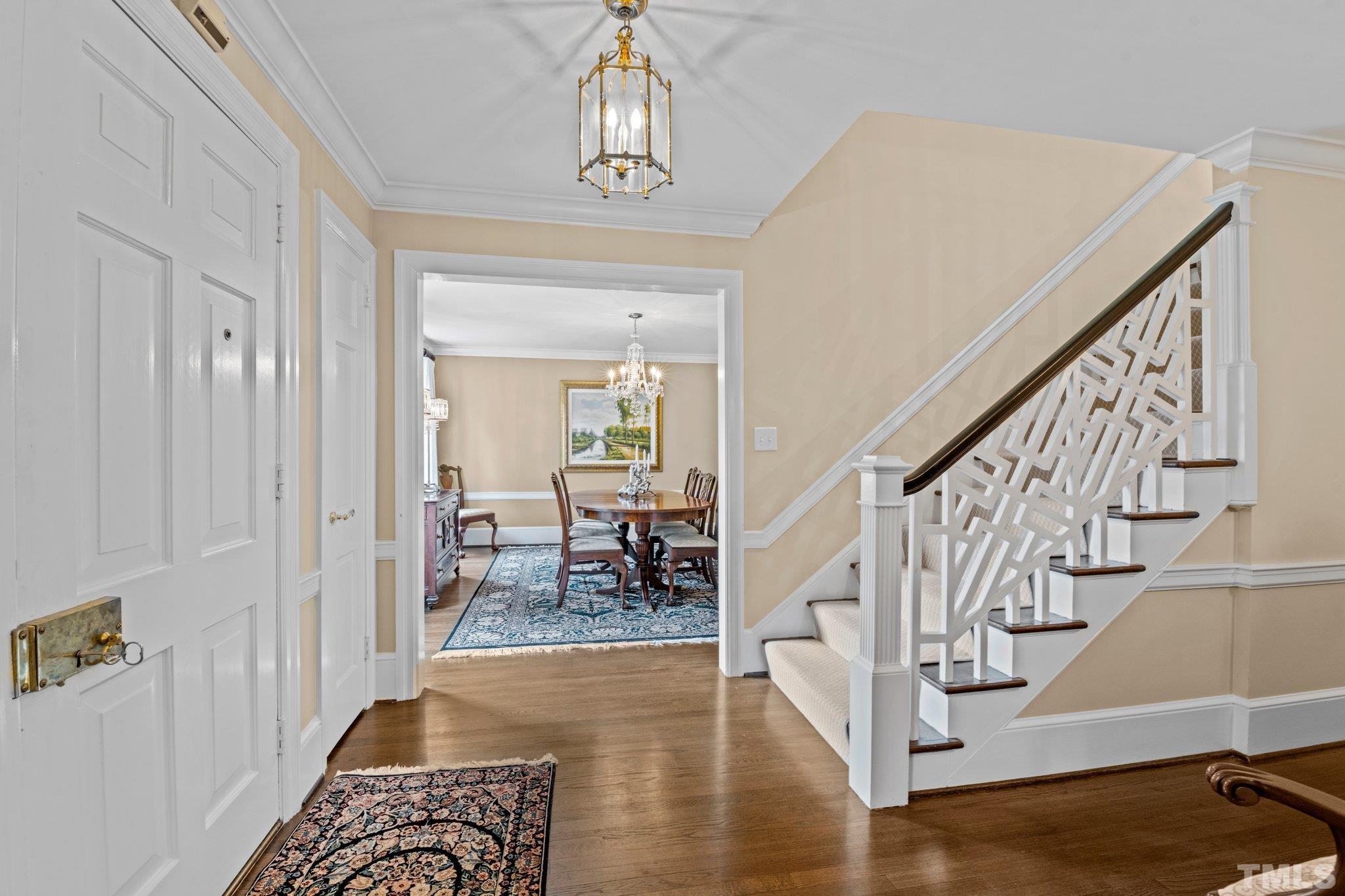 Welcoming Foyer with beautiful hardwood flooring, crown molding through out, and access to Dining Room and Living Room.