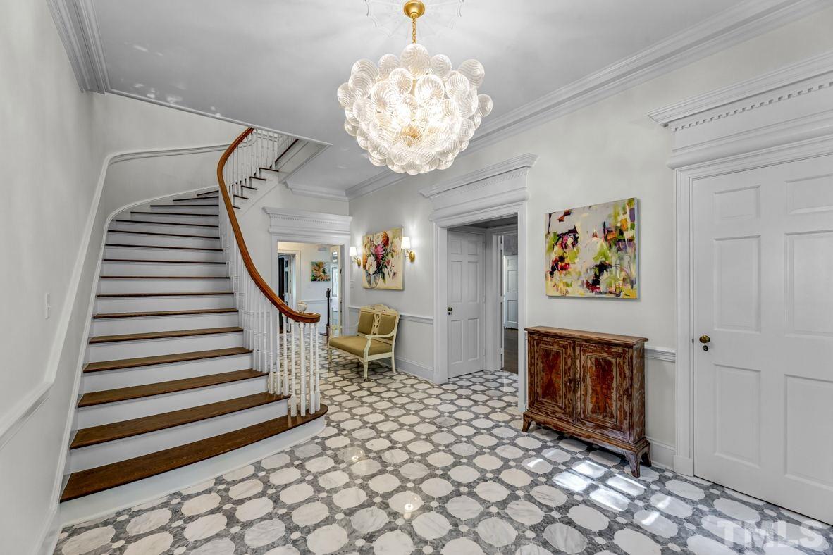 Entry with curved staircase and marble flooring