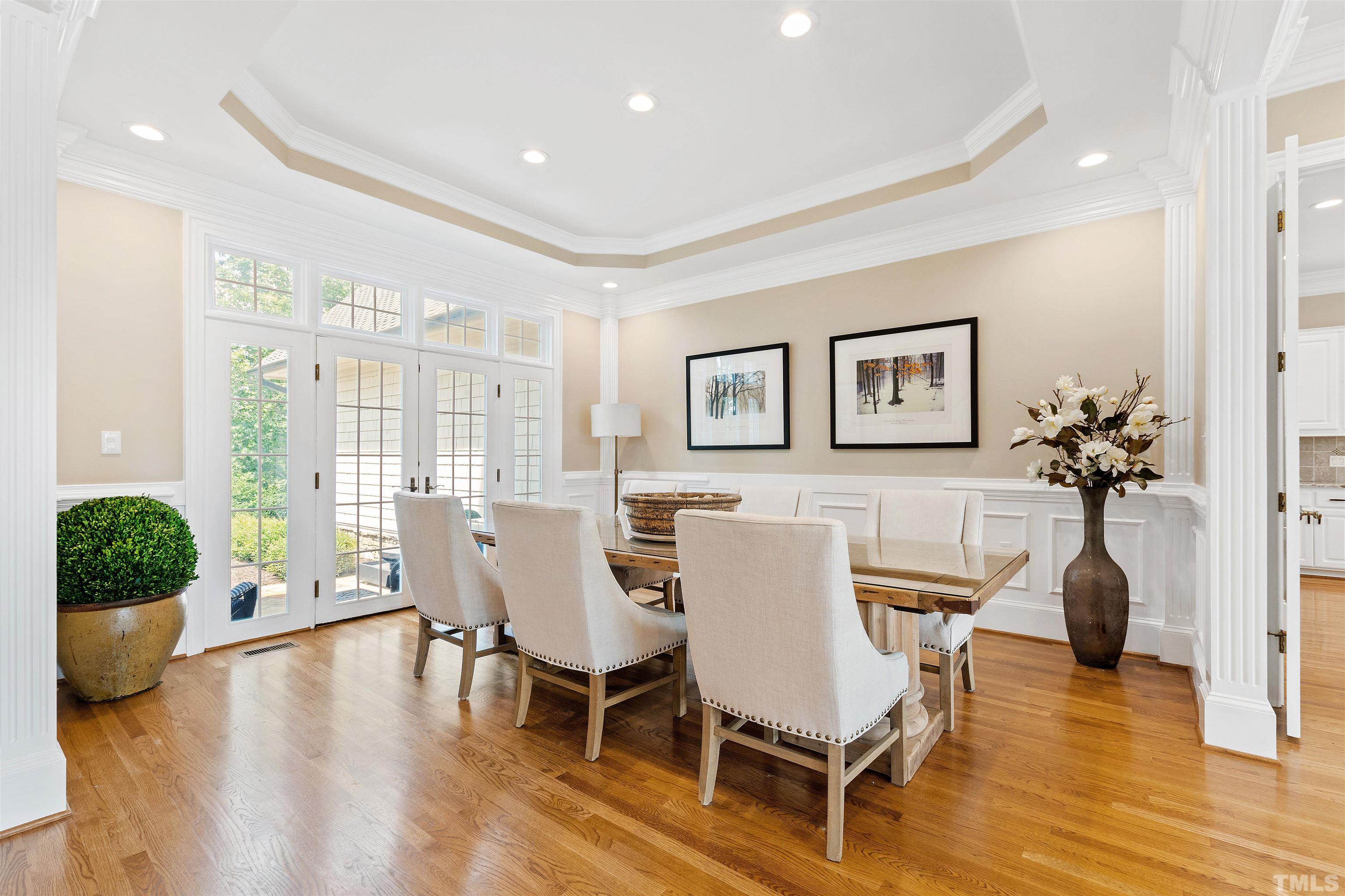 Separate Dining Room with tray ceiling, wainscoting
