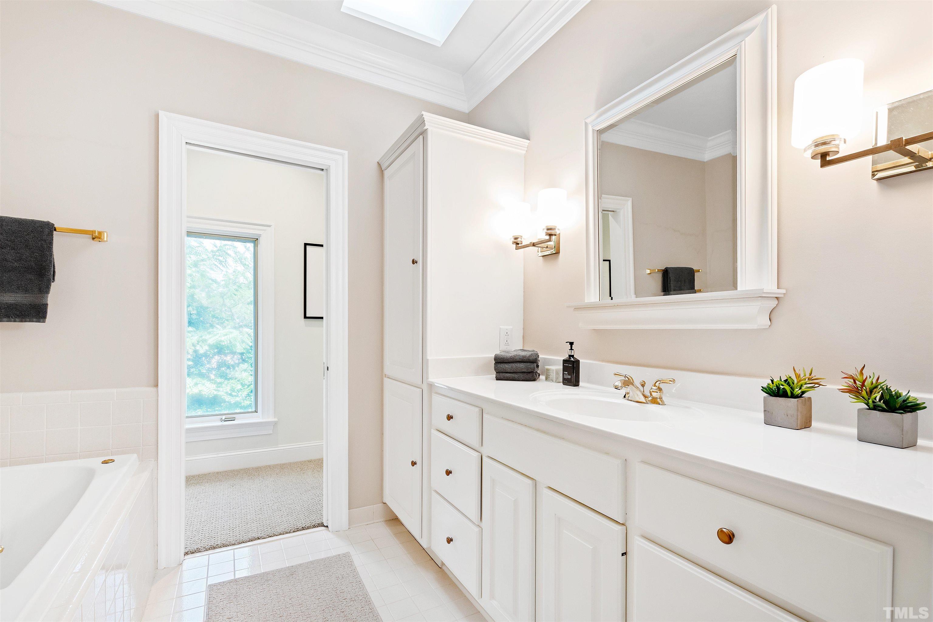 En-suite bathroom with dual vanities, walk-in shower and tub