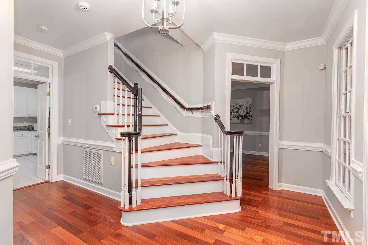 Elegant curved stair case in custom trimmed foyer.